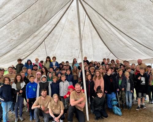 Das Foto zeigt eine Gruppe von Kindern und Jugendlichen gemeinsam mit Landrat Dusch und Sozialdezernent Ernst auf einem Zeltplatz. 