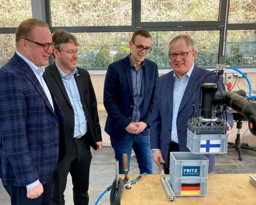 Stadtdirektor Timonen, Landrat Prof. Dusch sowie die Geschäftsführer Peteroff und Fritz (von links) schauen sich bei der Firma Fritz Automation in Forbach einen Roboter an.