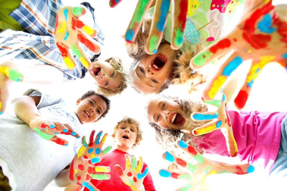 Kinder Das Foto zeigt fünf Kinder, die im Kreis stehen und von oben auf die Kamera schauen.