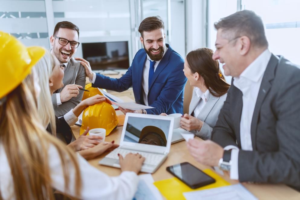 Menschengruppe am Schreibtisch Das Foto zeigt eine Menschengruppe am Schreibtisch.