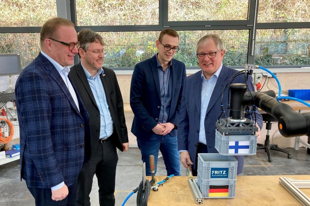 Stadtdirektor Timonen, Landrat Prof. Dusch sowie die Geschäftsführer Peteroff und Fritz (von links) schauen sich bei der Firma Fritz Automation in Forbach einen Roboter an.